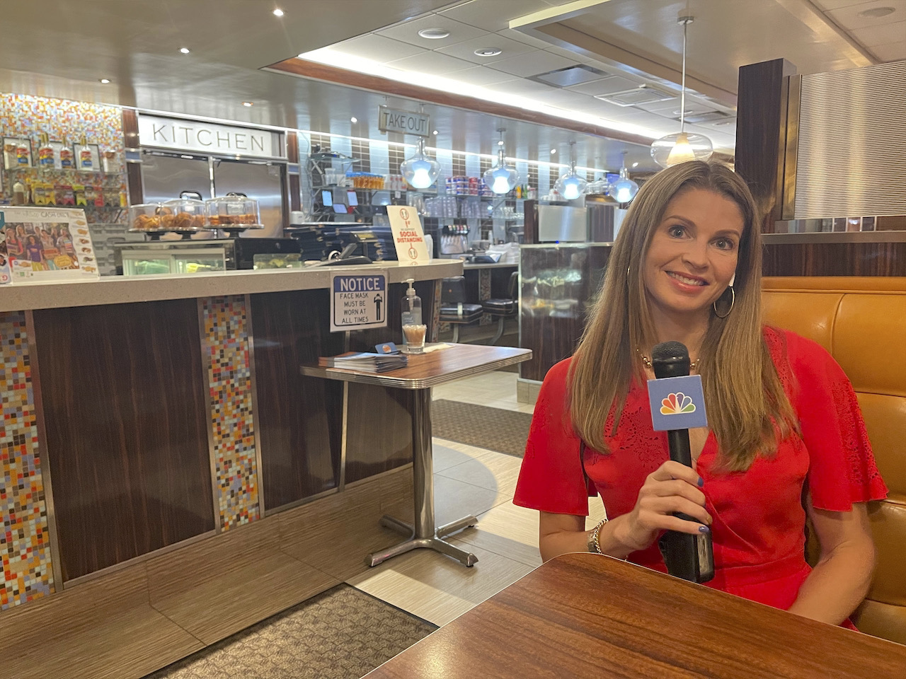 Jen anchoring in the field, sitting in a diner booth, smiling in a red dress.